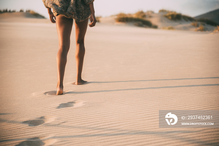 一个年轻黑人妇女在沙漠沙丘的沙滩上行走的腿