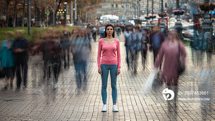 The young girl stands on the crowded urban street