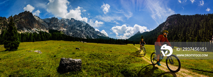 骑自行车的女人和男人在多洛米蒂山脉和风景区骑自行车。情侣骑山地车enduro-tra