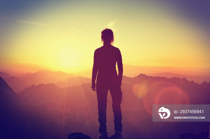 Hiker on a mountain top at sunset. Woman admiring mountain landscape in High Tatra Mountains, Poland