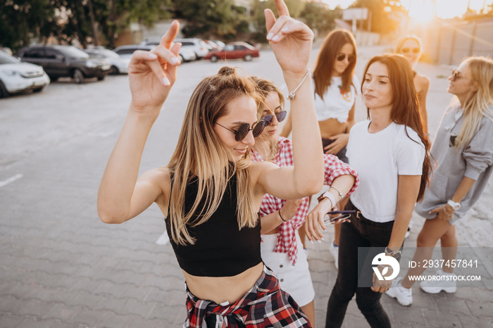 Six young women dance in a car park