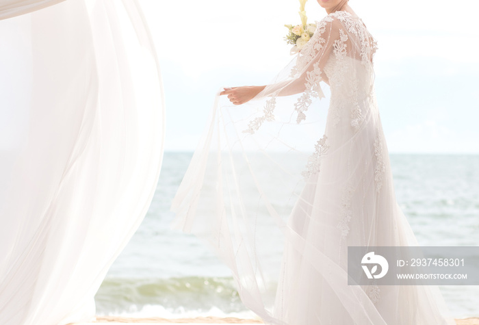 happy bride with boquet on the beach.