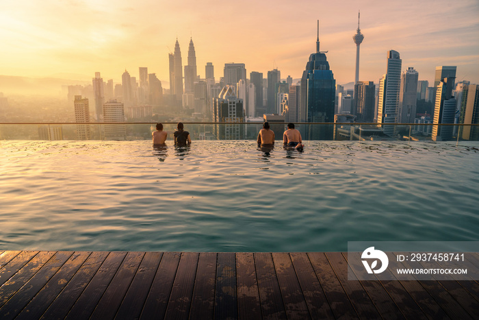 日出时，游客在酒店屋顶的游泳池中欣赏吉隆坡城市的天际线