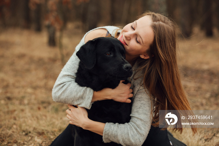 lots of love in one photo. dog friend man. girl hugging a black labrador. love for animals. portet w