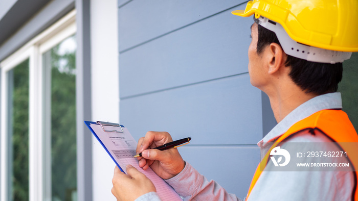 The inspector or engineer is checking the building structure and the requirements of the wall paint.