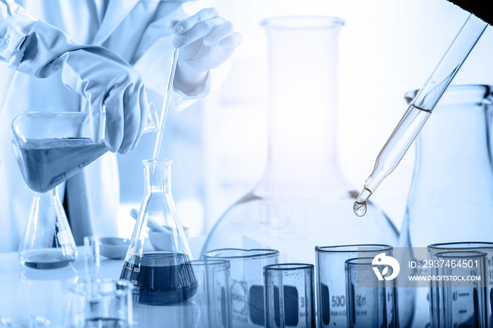 hand of scientist holding flask with lab glassware and test tubes in chemical laboratory background,