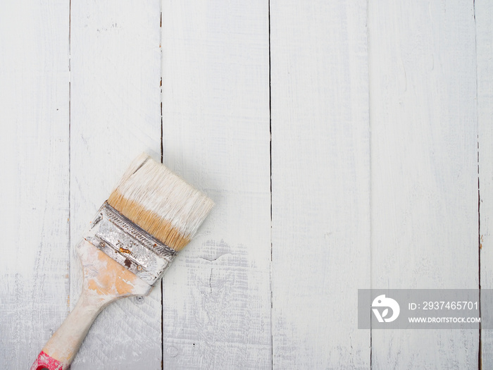 brush and blue paint with old wood texture of a white wooden wall