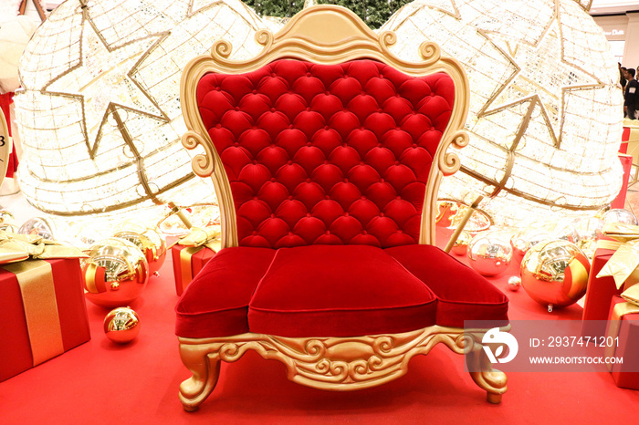 Luxurious red chair Santa Claus throne surrounded by multiple gift boxes