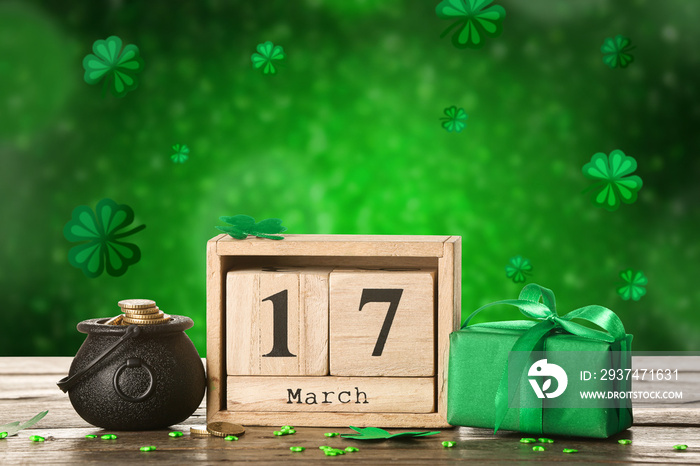 Pot with coins, calendar and gift box on table against green background. St. Patricks Day celebrati