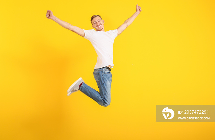 Jumping man in stylish t-shirt on color background