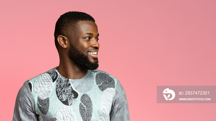 Positive black man in african shirt looking at copy space