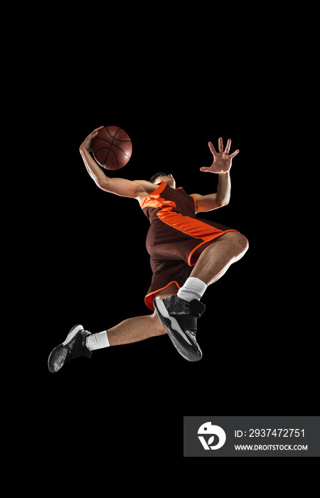 Young professional basketball player in action, motion isolated on black background, look from the b