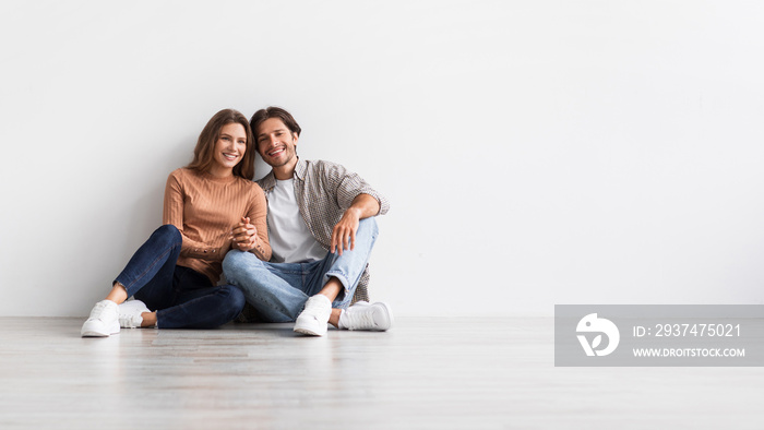 Satisfied millennial european man and lady holds hands, planning future interior