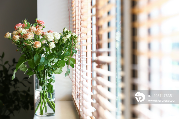 Vase with bouquet of beautiful fresh roses on windowsill