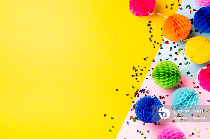 Festive yellow background with colorful paper balls. Greeting card concept voor birthday, party, inv