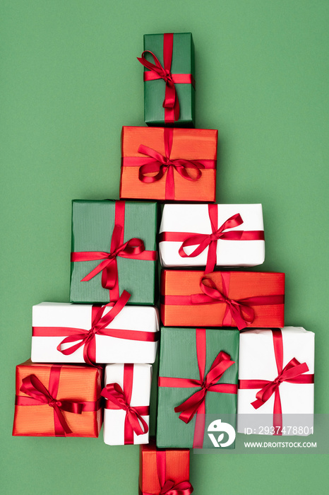 top view of colorful gift boxes in shape of christmas tree on green background