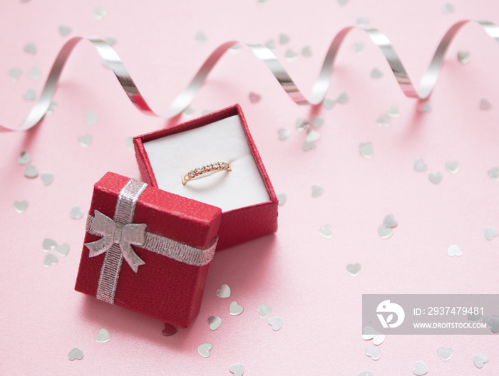 Red gift box with a jewelry on festive background.  