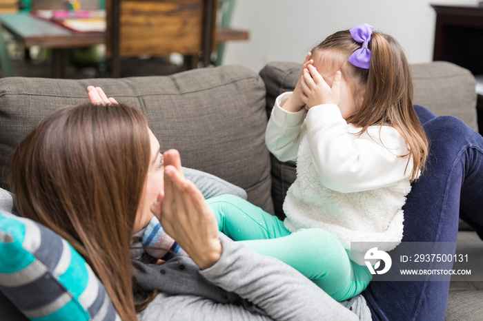 Girl Covering Eyes While Playing Peekaboo With Mom