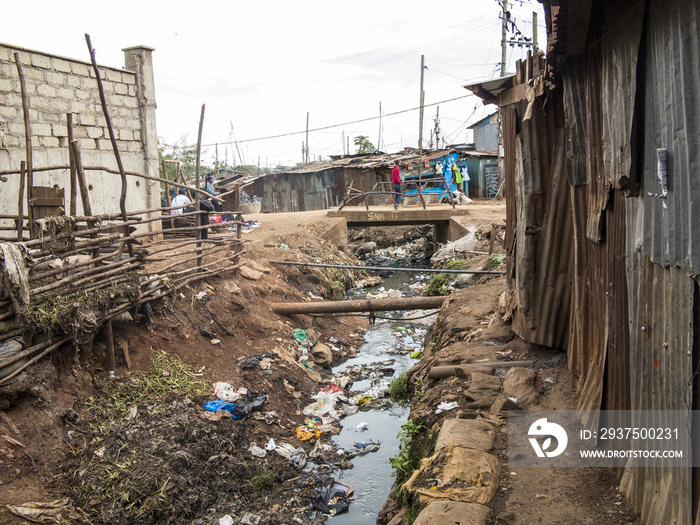 Open sewer and tin shacks in a slum in Africa