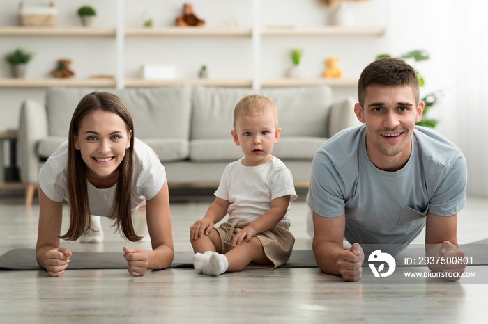 Sporty Family. Happy Young Parents And Little Infant Son Training At Home