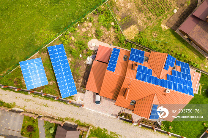 带蓝色闪亮太阳能光伏电池板的新现代住宅小屋鸟瞰图