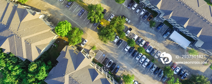 Panorama aerial view of apartment garage with full of covered parking, cars and green trees of multi