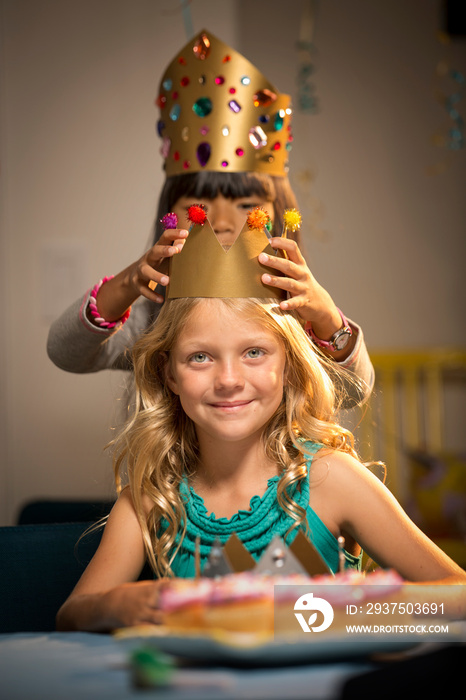 Girl wearing crown to friend