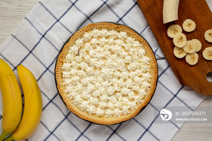 Homemade Tasty Banana Cream Pie on a white wooden background, top view. Flat lay, overhead, from abo