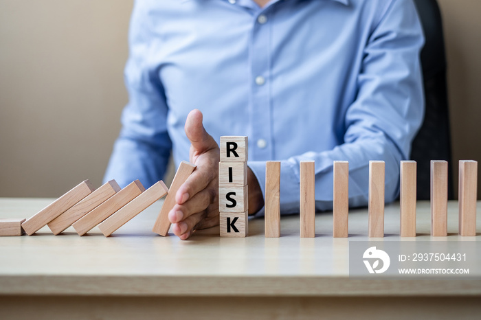 Businessman hand Stopping Falling wooden Blocks or Dominoes. Business, Risk Management, Solution, In