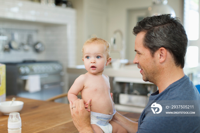 Father and cute baby son at dining table