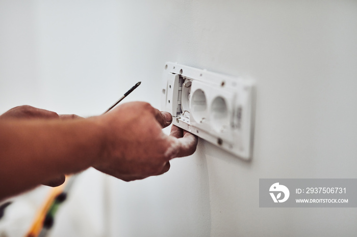 Electrician repairing / fixing wires in the wall.