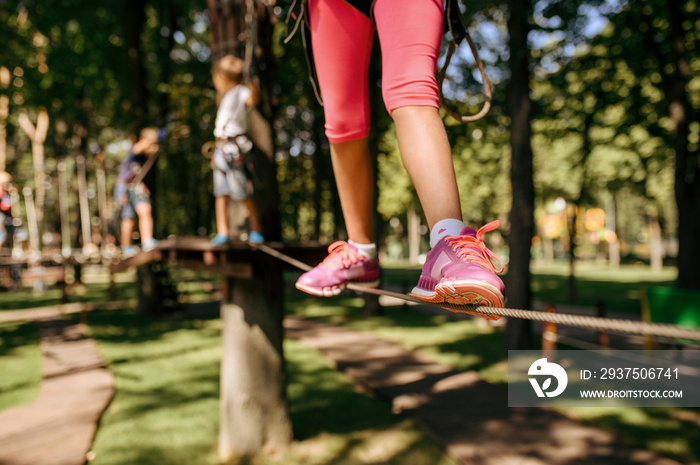 Little brave girl climbs in rope park, playground