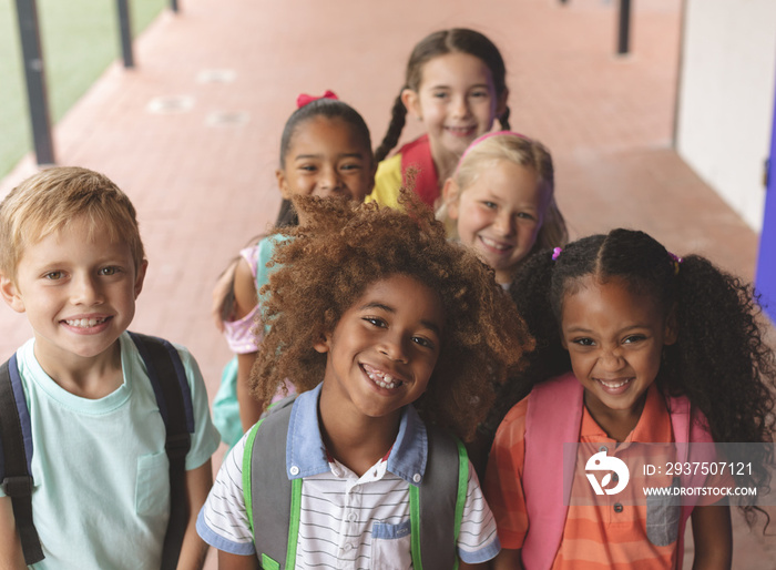 Happy school kids standing in corridor