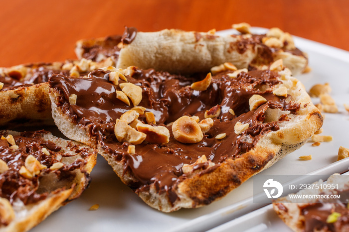 Bruschetta dolce fatta di pasta per la pizza con nutella e nocciole tostate e sbriciolate