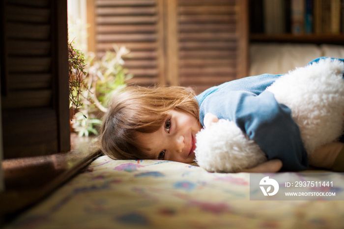 Portrait of smiling girl lying on bed