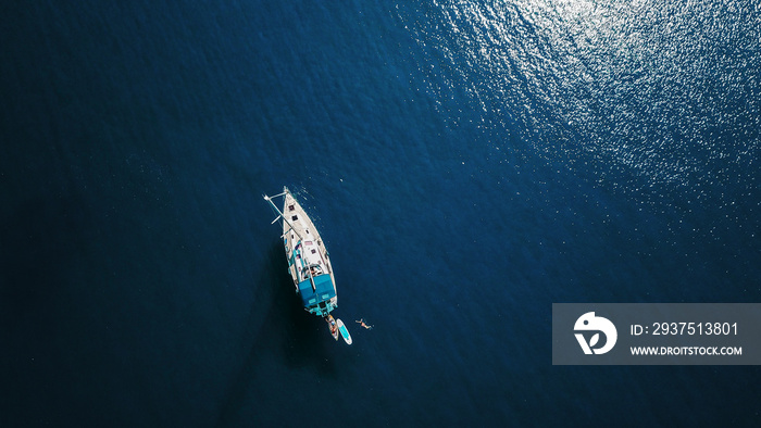 Aerial shot of beautiful blue lagoon at hot summer day with sailing boat. Top view.