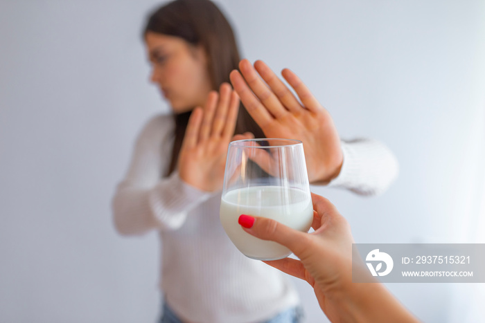 Lactose intolerance, health problem with dairy food products concept. Woman holding glass of milk ha