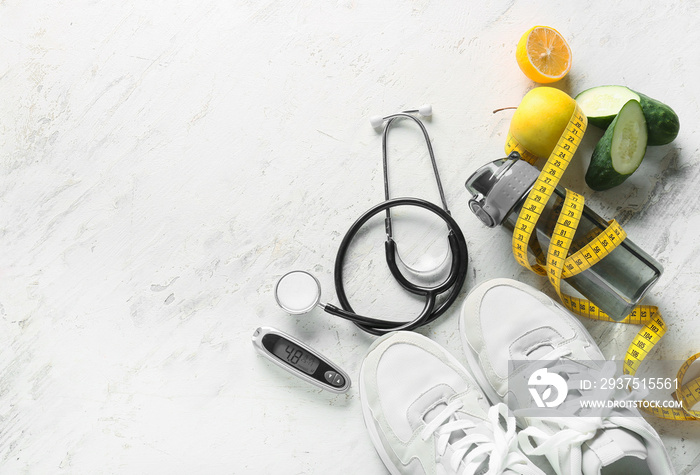 Sports shoes, measuring tape, stethoscope and glucometer on white background. Diabetes concept