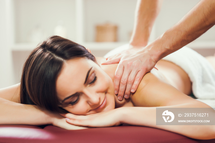 Young woman is enjoying massage on spa treatment.