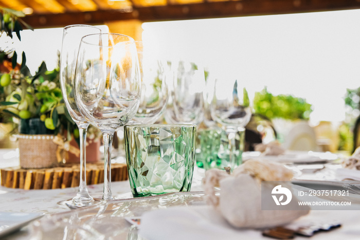 客人餐桌上餐具和亚麻布旁边的空杯子。