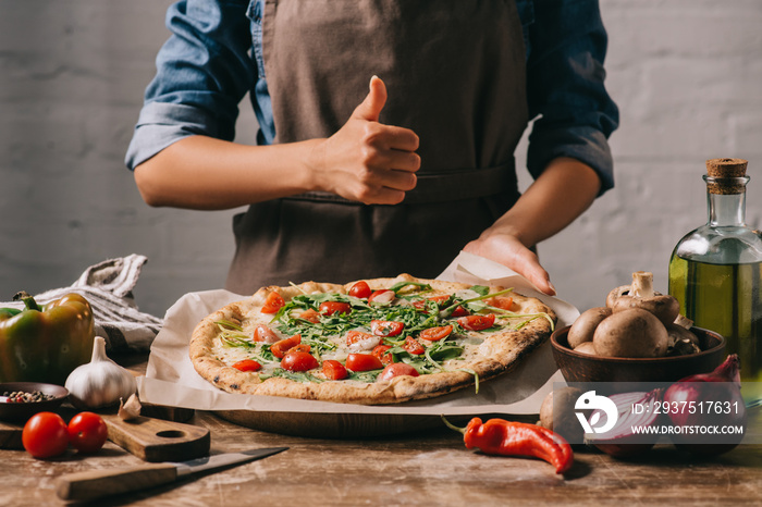 一张穿着围裙的女人用拇指在桌面上吃意大利披萨的短镜头