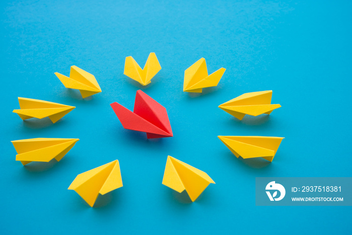 领导理念。红色纸飞机折纸激励与蓝色背景上的黄色小飞机会面