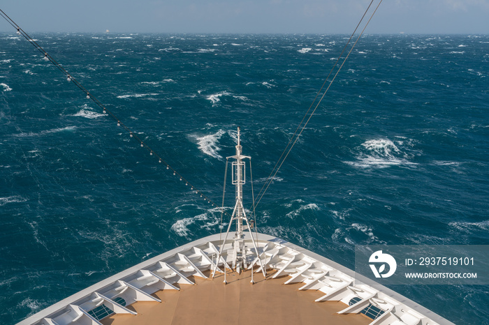 View from front at the rough seas and waves forward of bow of cruise ship