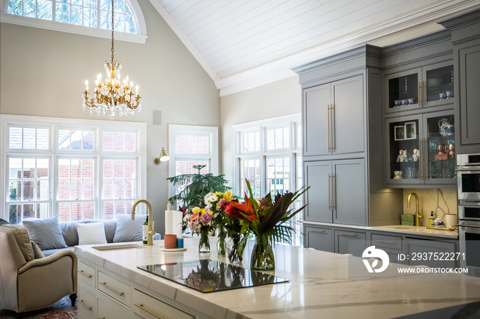 Open Concept Elegant and Spacious Kitchen with Marble Countertops, Chandelier, and Two Toned Cabinet