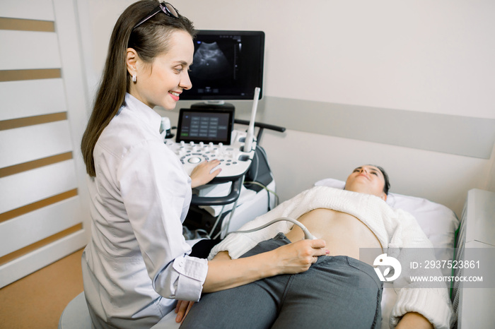 Female doctor performs ultrasound examination of pelvic organs of her female patient for diagnostic 