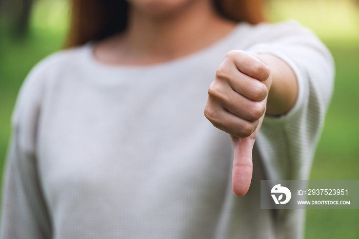 Closeup image of a woman making thumbs down hands sign