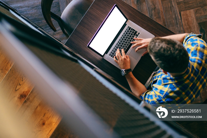 Top view of Caucasian freelancer working on laptop. Hands on keyboard.