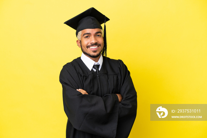 Young university graduate Colombian man isolated on yellow background with arms crossed and looking 