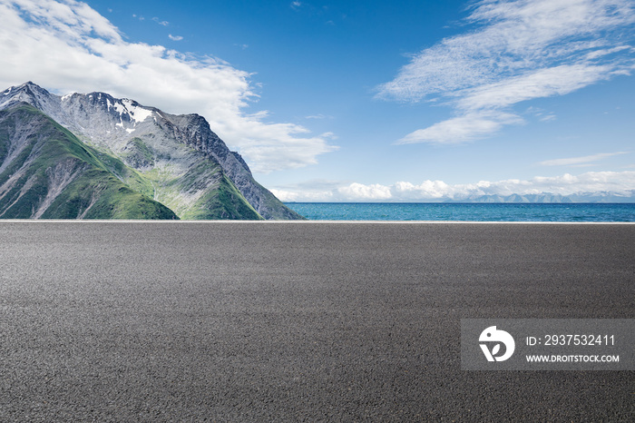 Asphalt road and mountain with lake natural scenery under blue sky