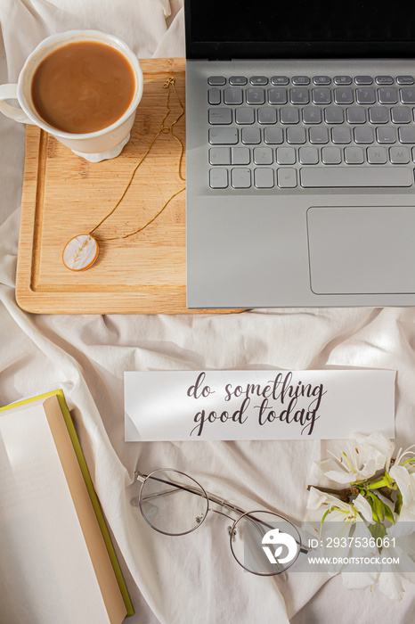 Modern home office desk with laptop, book, tea latte cup on messy bef background. Flat lay, top view